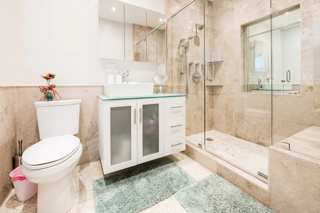 Master bathroom with 2 person walk-in shower has 3 Danze shower heads and sitting bench.
