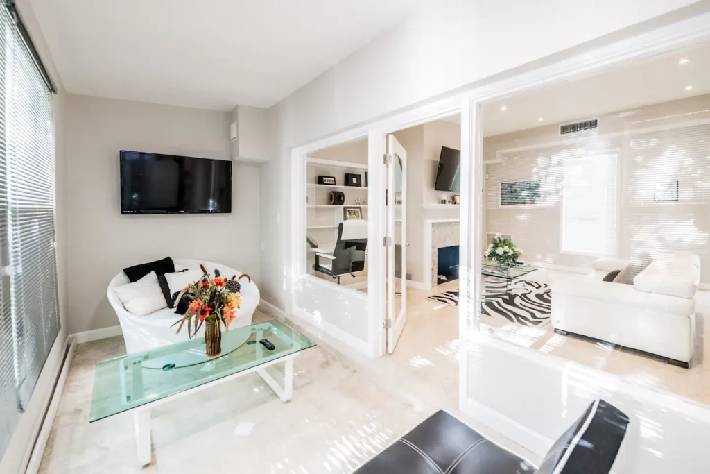 Sunroom-A full size Futon, glass table and a wall-mounted 50" 4K SmartTV. Sunroom- could be lounge and additional sleep area. Windows shades installed for privacy.