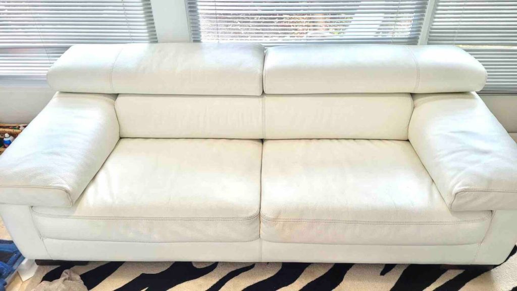 White leather pullout couch in sunroom.